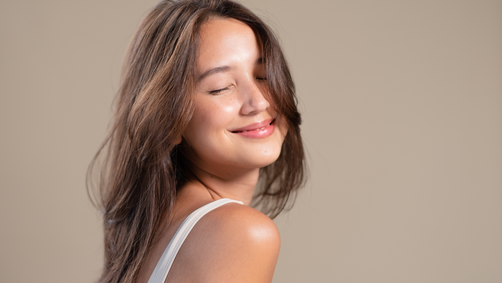 mulher sorrindo, de olhos fechados, com expressão de amor próprio